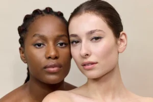 Medium shot of two women's face with dark eye pencil makeup and lipstick applied